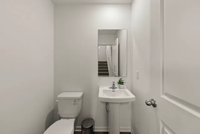 a bathroom with a sink toilet and mirror