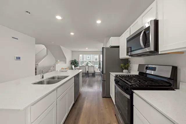 a kitchen with stainless steel appliances granite countertop a sink stove and cabinets