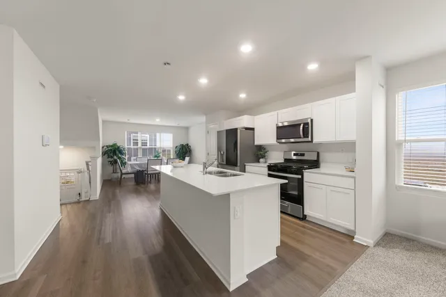 a kitchen with white cabinets and stainless steel appliances