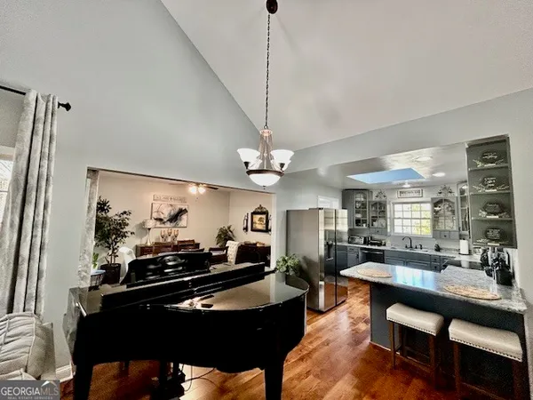 a living room with couches a dining table and chairs with wooden floor
