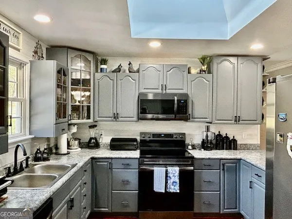 a kitchen with stainless steel appliances granite countertop a sink stove and refrigerator