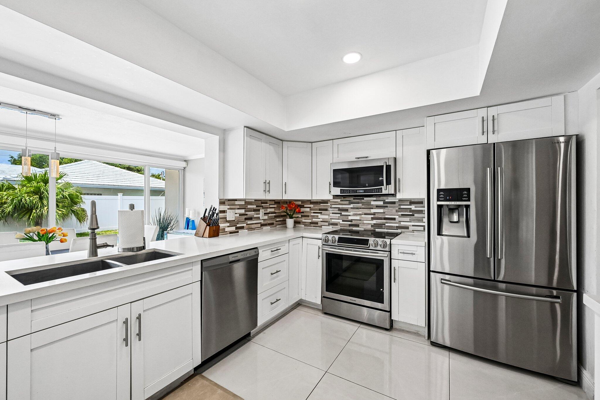 2940 Northeast 39th Court Lighthouse Point, FL 33064 - Photo 11 of 42 a kitchen with a sink stainless steel appliances and cabinets