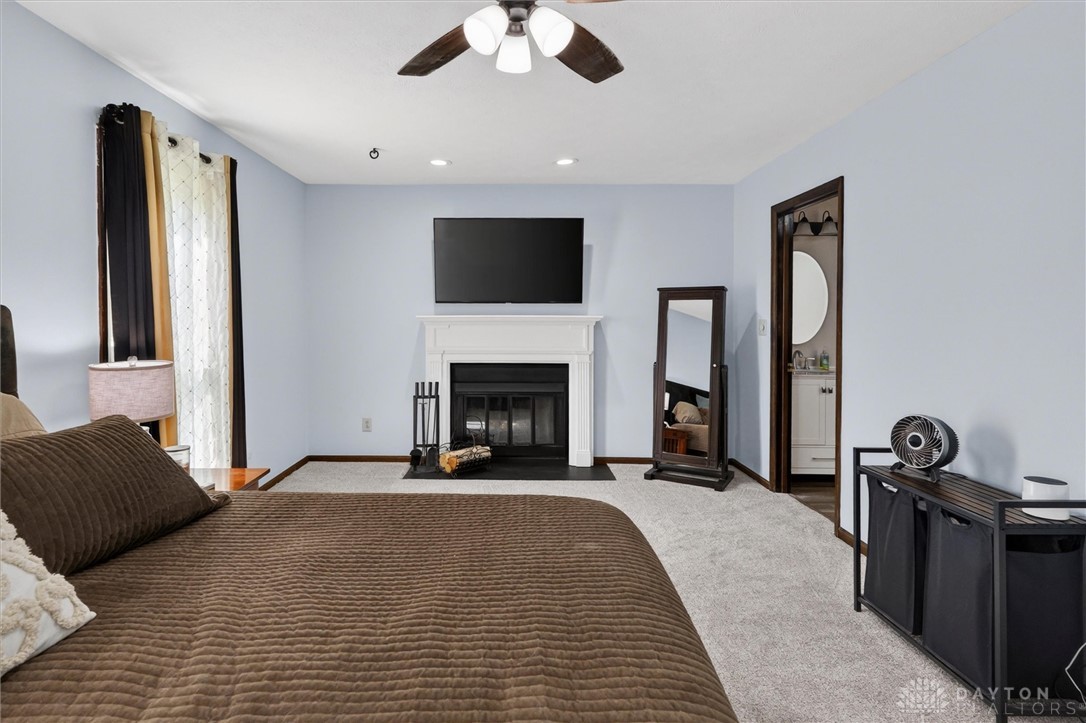 2165 Stewart Road Xenia, OH 45385 - Photo 34 of 59 This spacious room features a cozy fireplace, soft carpeting, and convenient access to a private bathroom.