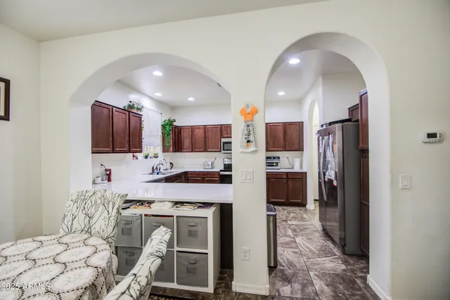 a kitchen with stainless steel appliances kitchen island granite countertop a refrigerator and a stove top oven