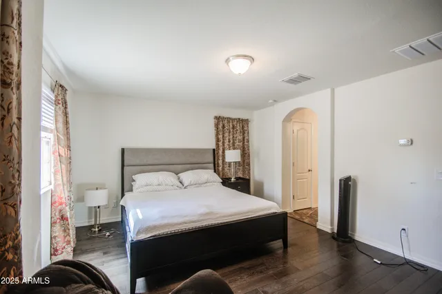 a bedroom with a bed and a large mirror on the dresser