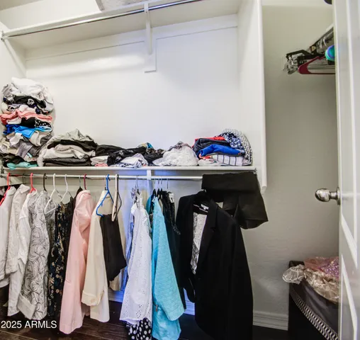 a view of walk in closet with clothes and shoes
