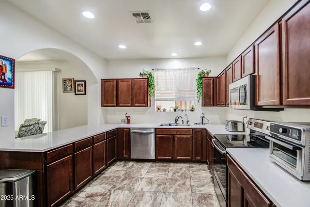 a kitchen with lots of counter top space sink and stainless steel appliances