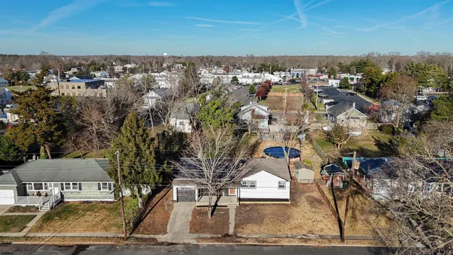 an aerial view of a city with lots of residential buildings and ocean view in back