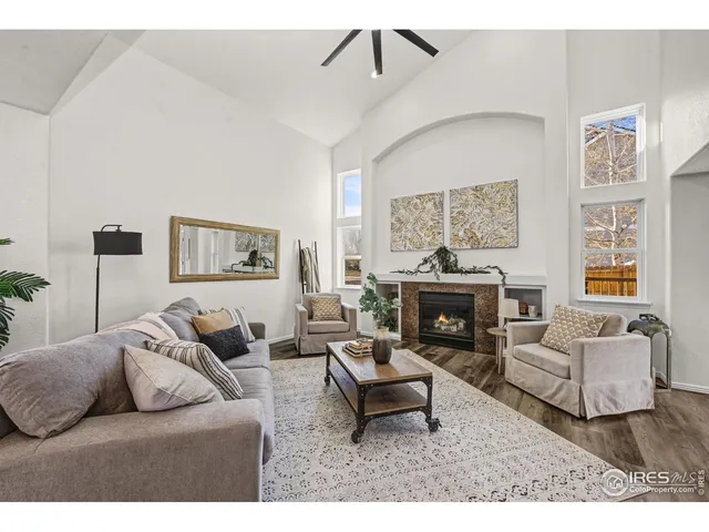 a living room with furniture a fireplace and a large mirror