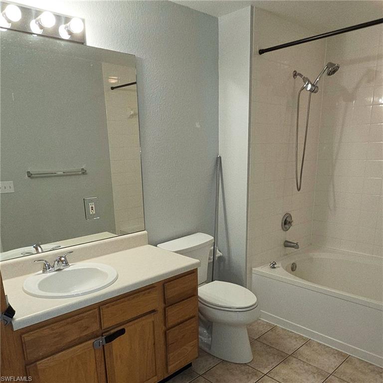 7940 Preserve Circle, Unit 935 Naples, FL 34119 - Photo 3 of 7 Full bath with shower / tub combination, light tile patterned flooring, vanity, and a textured wall