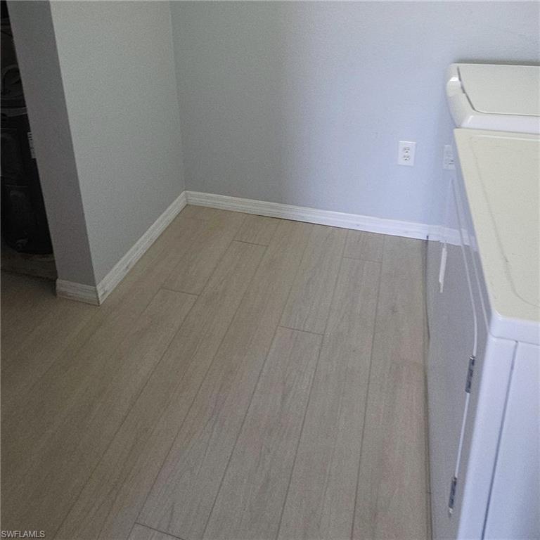 7940 Preserve Circle, Unit 935 Naples, FL 34119 - Photo 7 of 7 Laundry room with light wood-style flooring and washer and clothes dryer