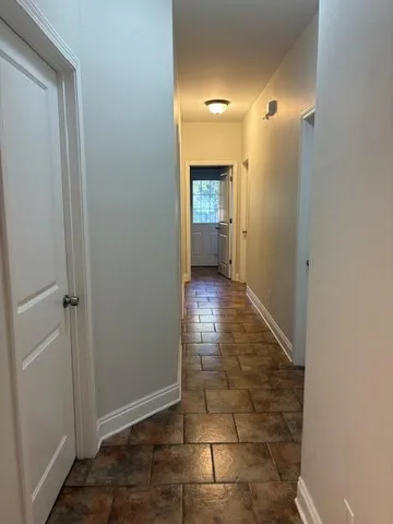 a bedroom with a bed a dresser and wooden floor