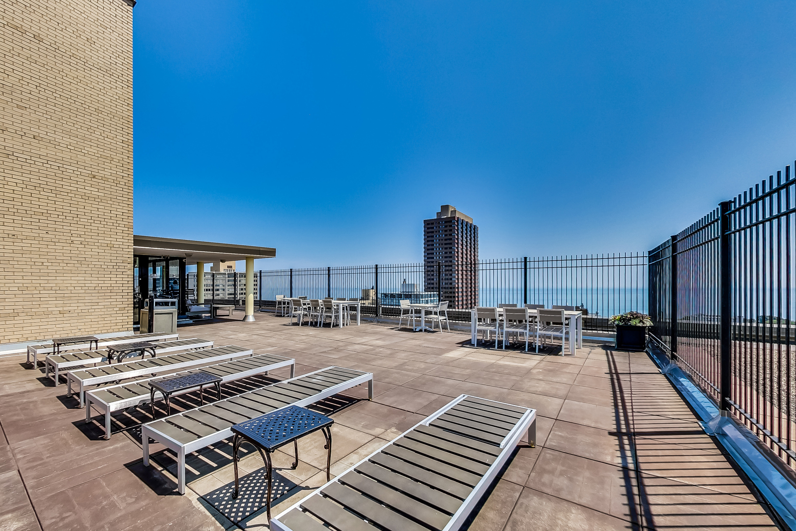 2930 North Sheridan Road, Unit 2111 Chicago, IL 60657 - Photo 18 of 31 a roof deck with table and chairs and potted plants