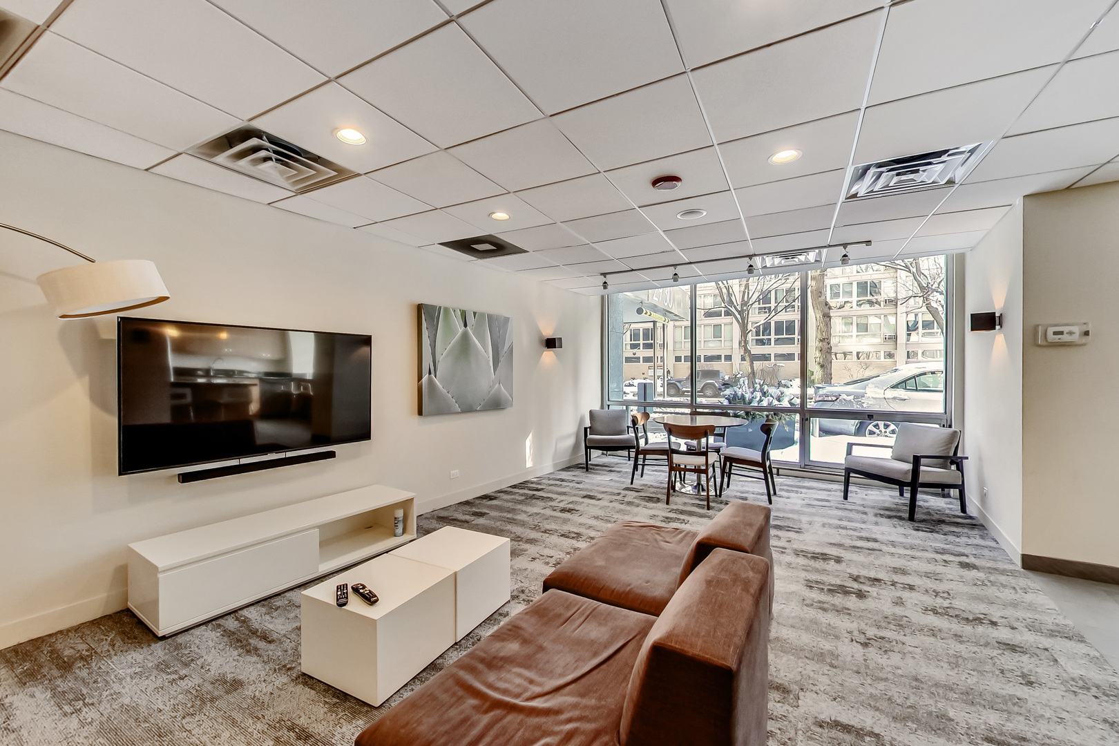 2930 North Sheridan Road, Unit 2111 Chicago, IL 60657 - Photo 25 of 31 a living room with furniture a flat screen tv and floor to ceiling window