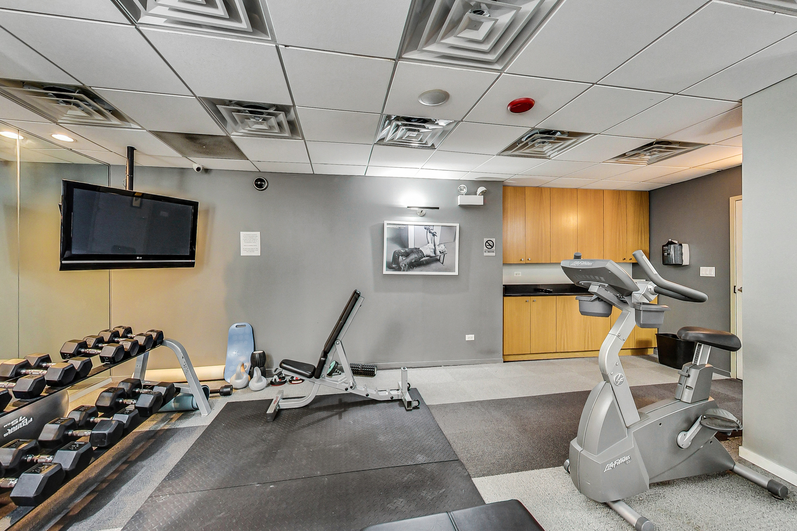 2930 North Sheridan Road, Unit 2111 Chicago, IL 60657 - Photo 27 of 31 a room with gym equipment and a flat screen tv