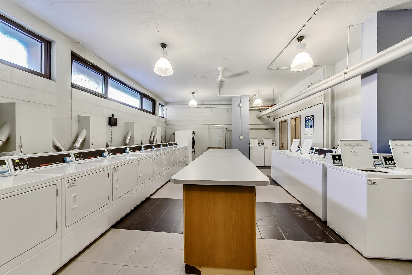 2930 North Sheridan Road, Unit 2111 Chicago, IL 60657 - Photo 29 of 31 a large white kitchen with lots of counter space wooden floor and appliances