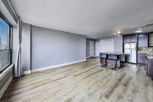 2930 North Sheridan Road, Unit 2111 Chicago, IL 60657 - Photo 7 of 31 a living room with hard wood floors and a kitchen