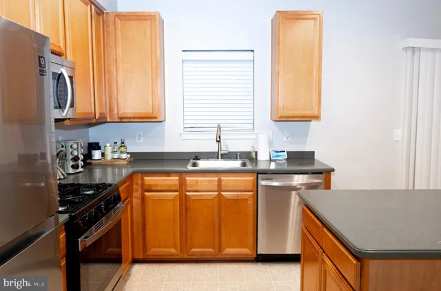 a kitchen with stainless steel appliances a sink stove and cabinets