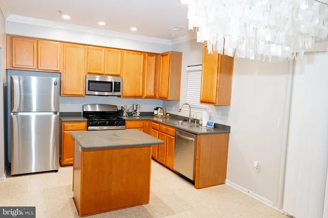 a kitchen with stainless steel appliances granite countertop a refrigerator a sink a stove a microwave and island