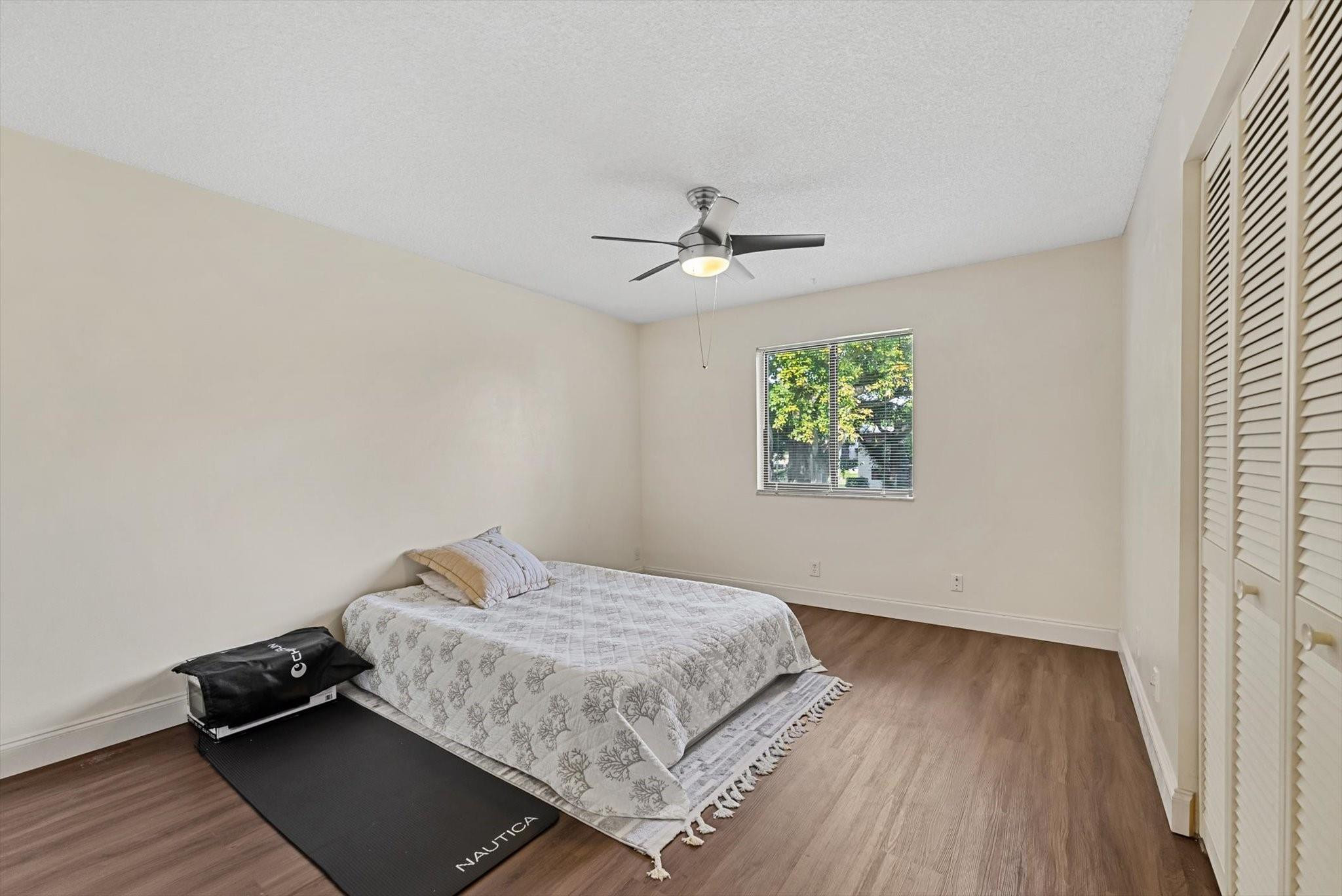 160 Northwest 70th Street, Unit 204 Boca Raton, FL 33487 - Photo 15 of 31 a bedroom with a bed and wooden floor