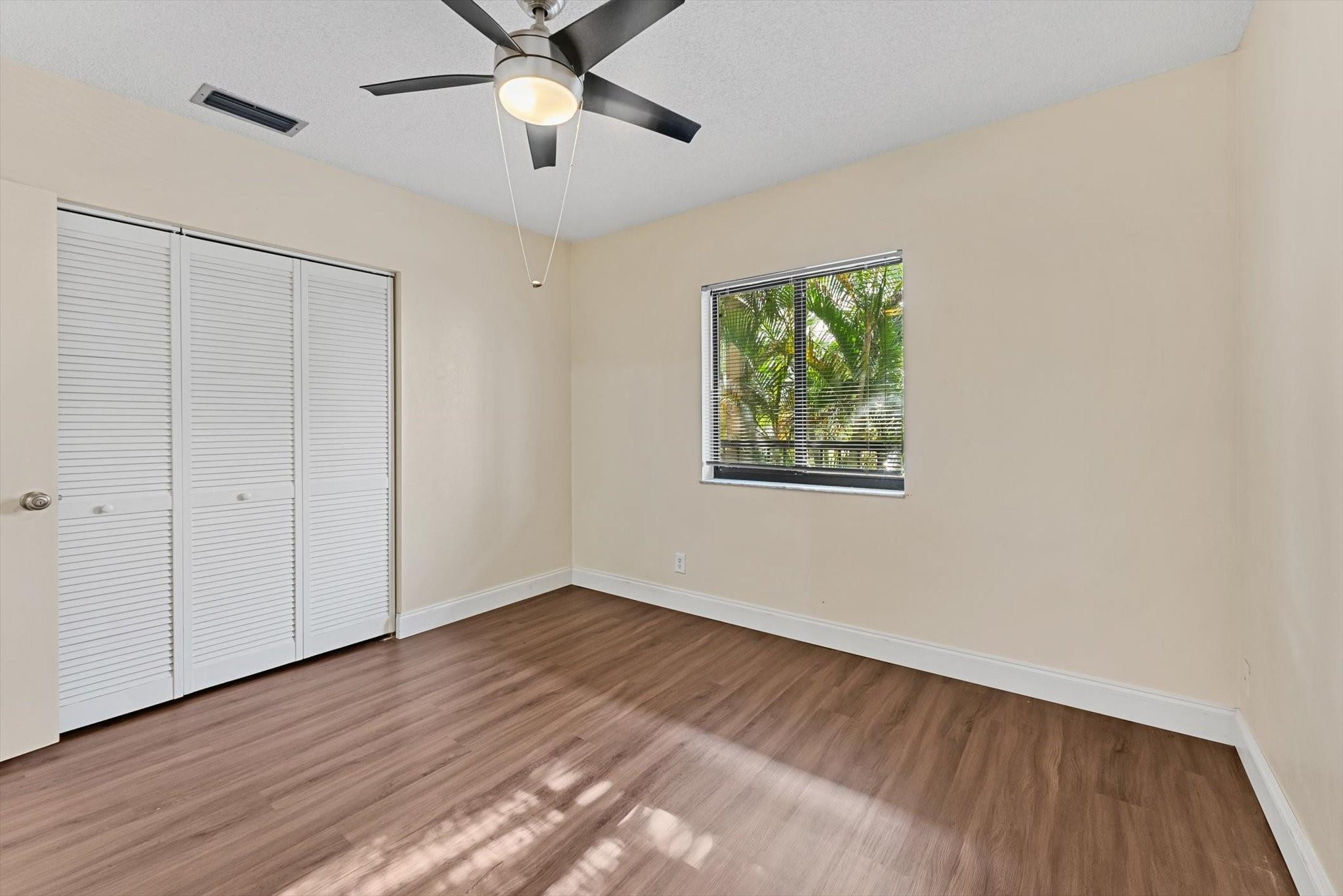160 Northwest 70th Street, Unit 204 Boca Raton, FL 33487 - Photo 19 of 31 a view of an empty room with wooden floor and a window