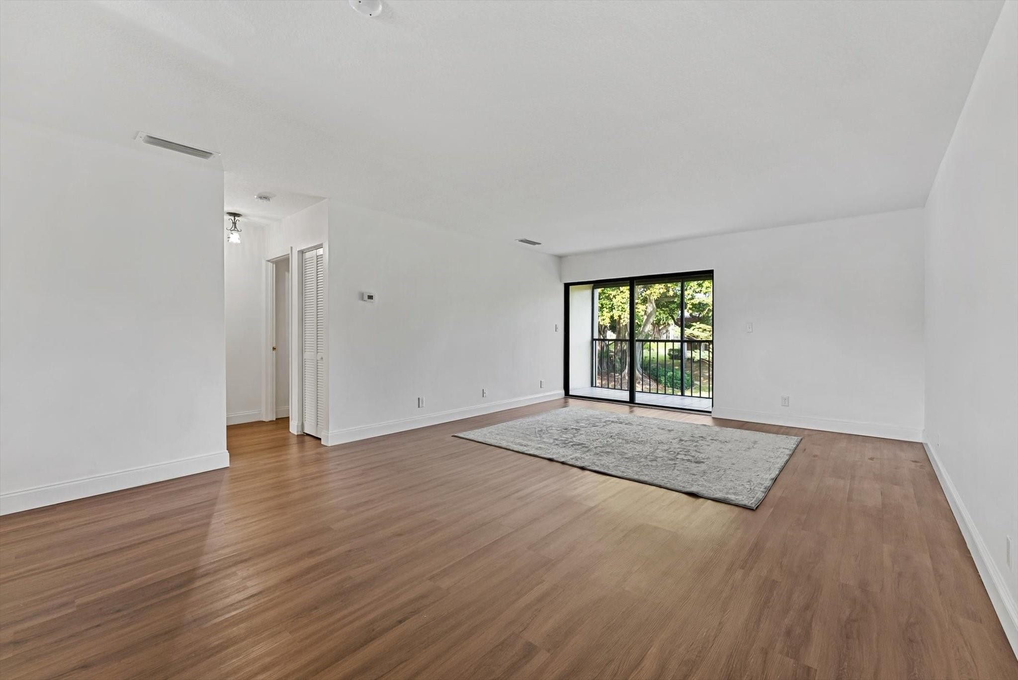 160 Northwest 70th Street, Unit 204 Boca Raton, FL 33487 - Photo 8 of 31 a view of an empty room with wooden floor and a window