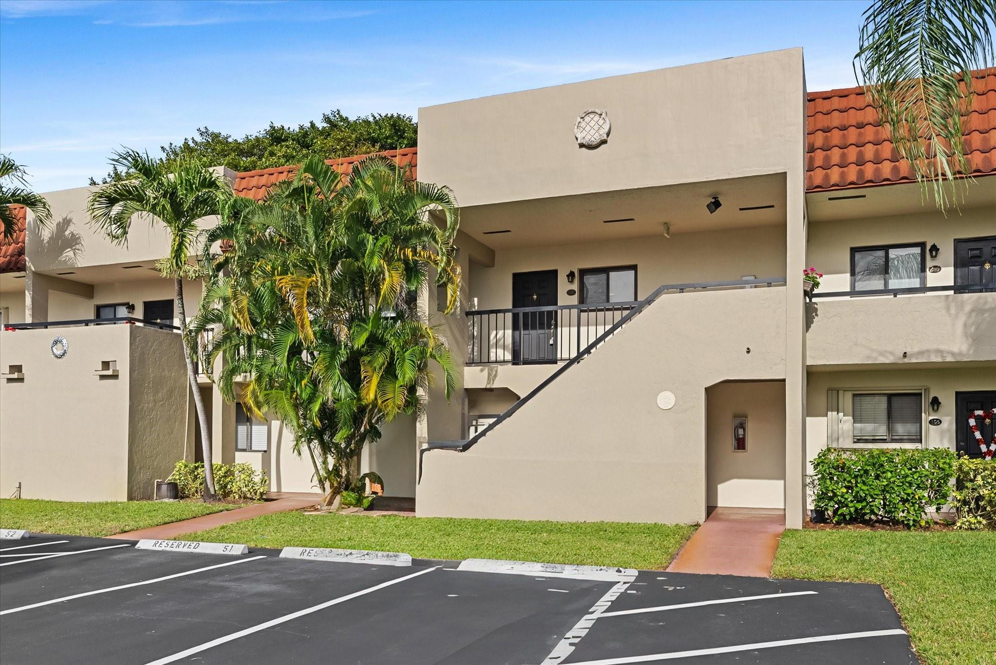160 Northwest 70th Street, Unit 204 Boca Raton, FL 33487 - Photo 9 of 31 a front view of a building with a garden and trees