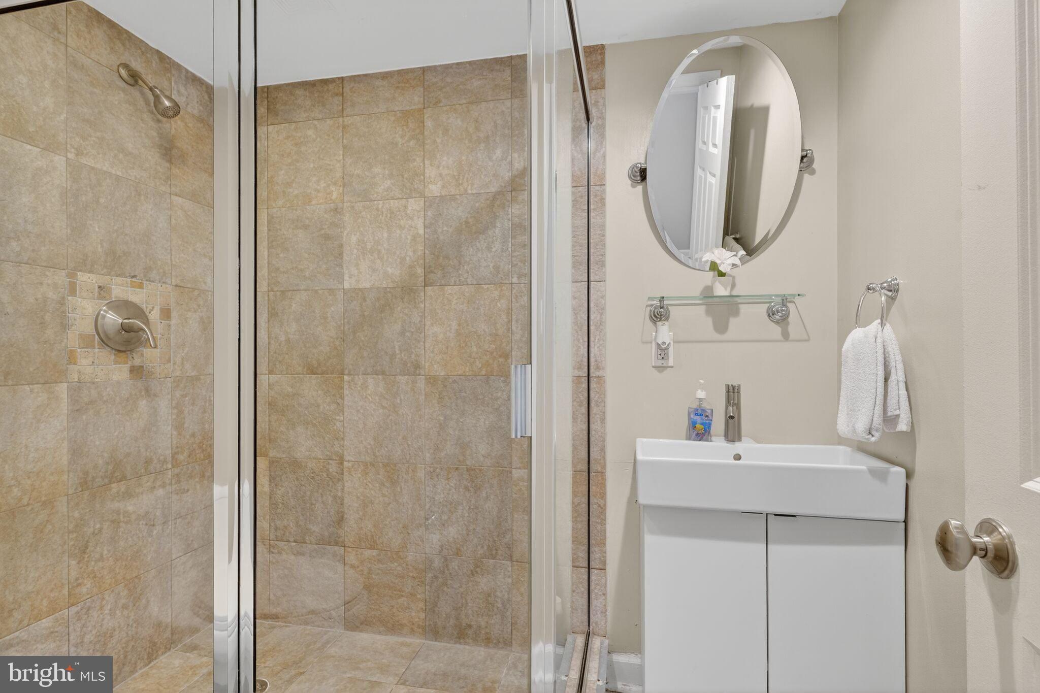 1337 Harvard Street Northwest, Unit 1 Washington, DC 20009 - Photo 14 of 20 a bathroom with a double vanity sink mirror and shower