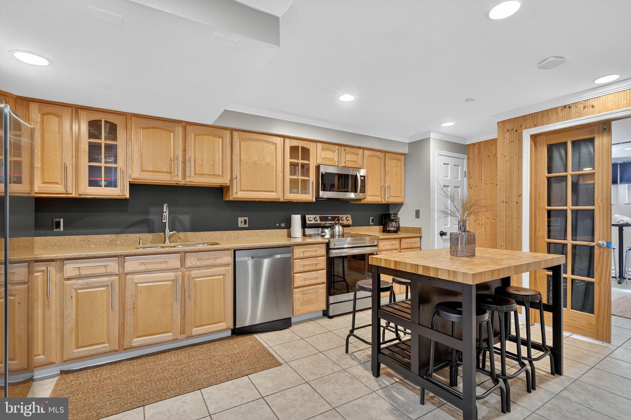 1337 Harvard Street Northwest, Unit 1 Washington, DC 20009 - Photo 6 of 20 a kitchen with stainless steel appliances granite countertop a stove top oven a sink a dining table and chairs