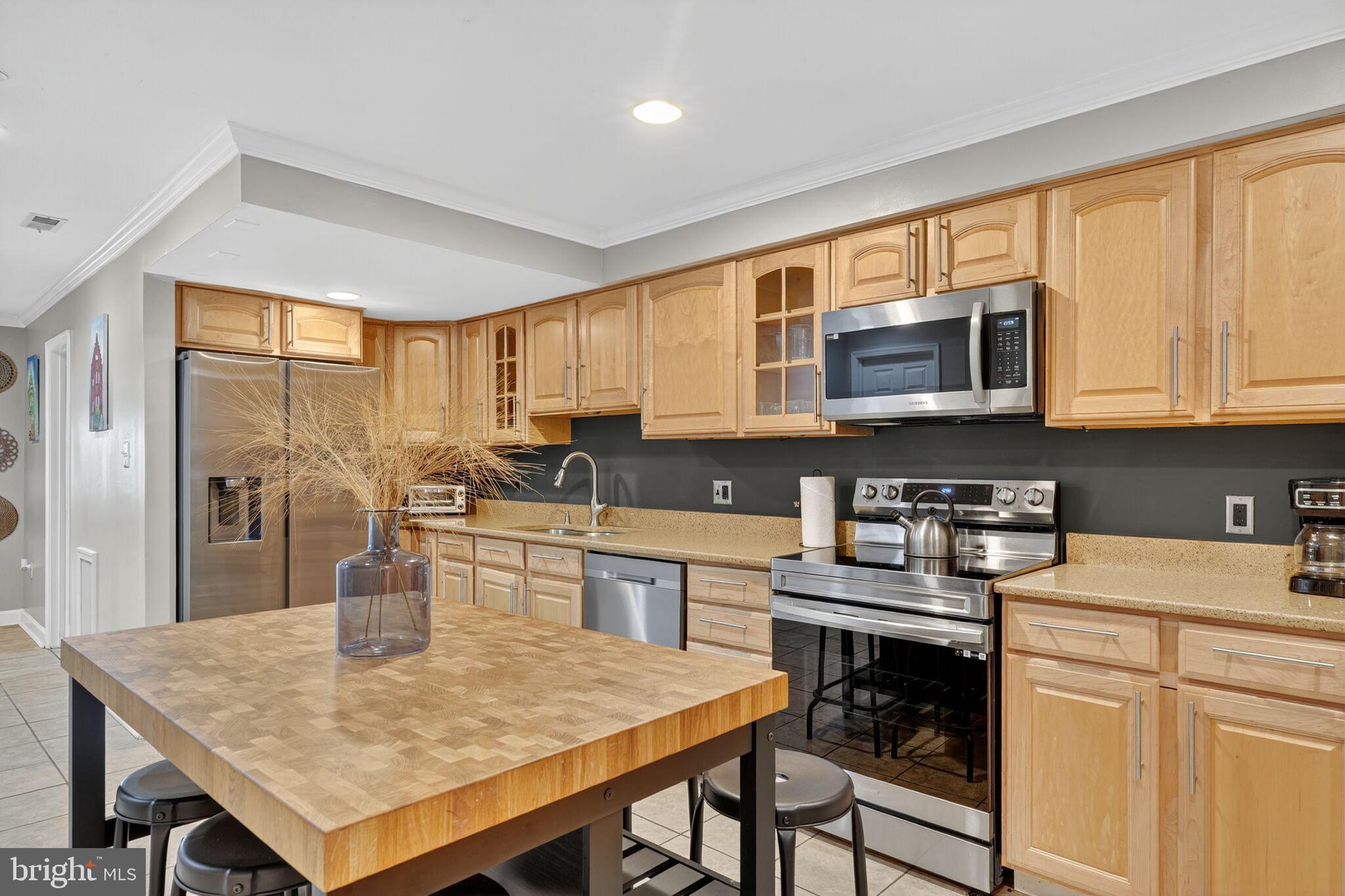 1337 Harvard Street Northwest, Unit 1 Washington, DC 20009 - Photo 7 of 20 a kitchen with a stove a sink a microwave a dining table and chairs