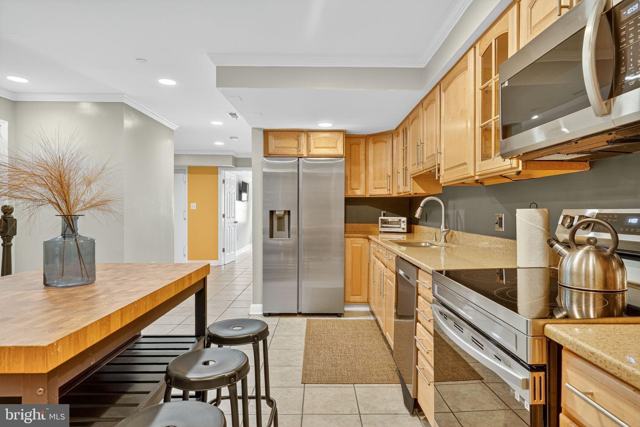 1337 Harvard Street Northwest, Unit 1 Washington, DC 20009 - Photo 8 of 20 a kitchen with stainless steel appliances granite countertop a sink and a refrigerator
