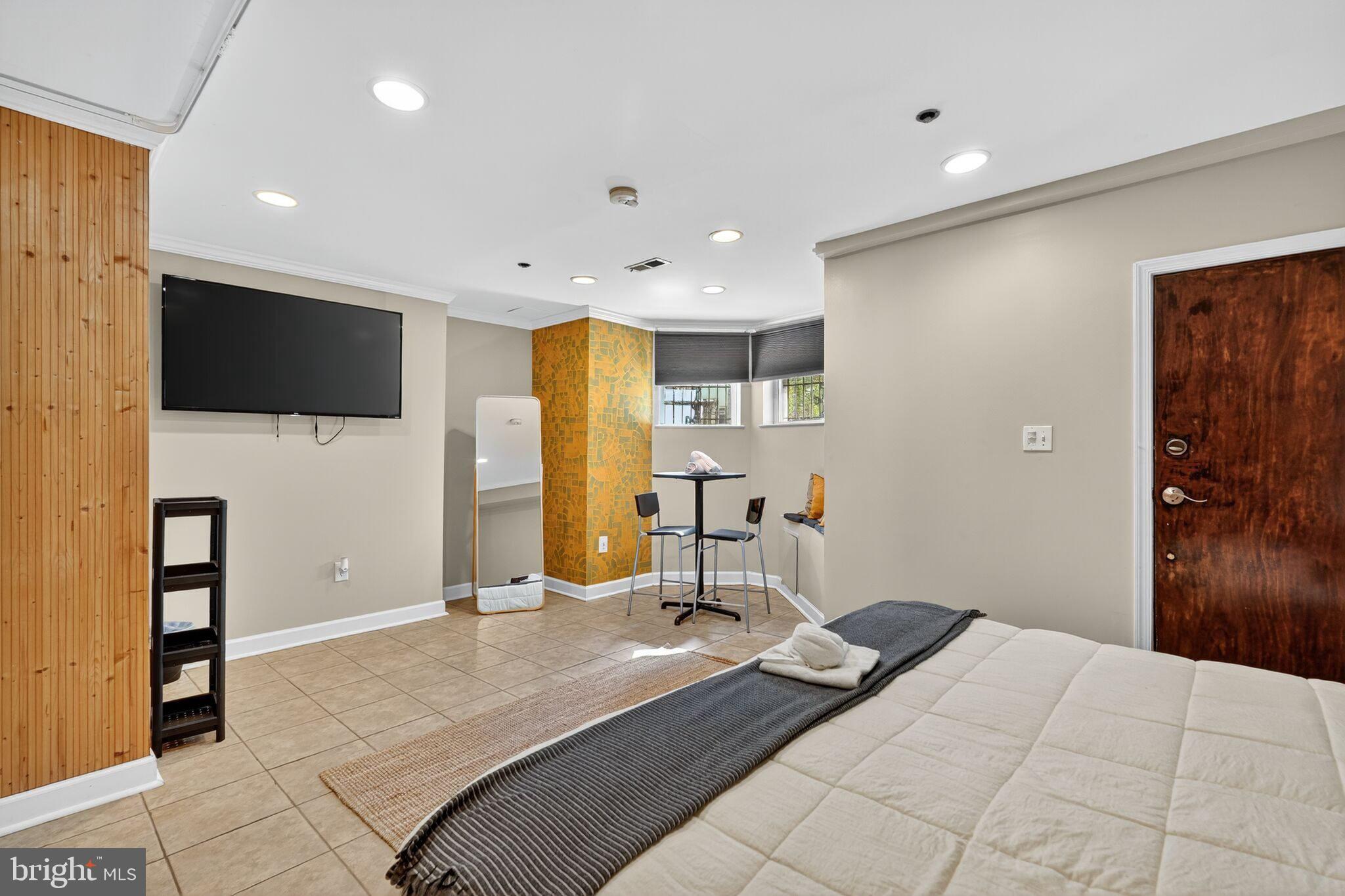 1337 Harvard Street Northwest, Unit 1 Washington, DC 20009 - Photo 10 of 20 a bedroom with a bed and a flat screen tv