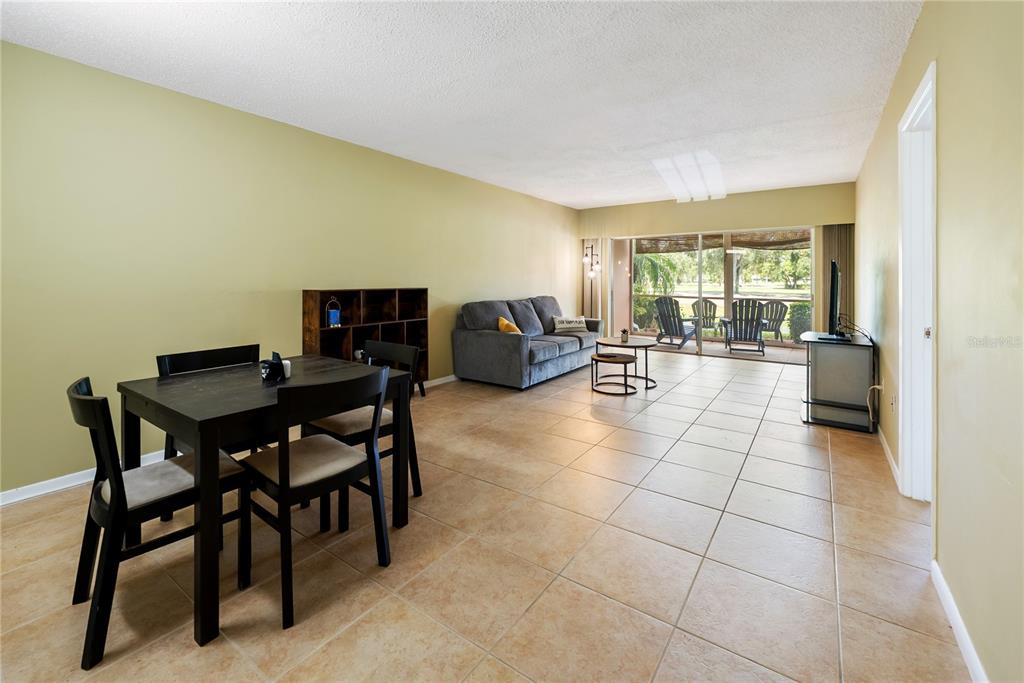 7351 West Country Club Drive North, Unit 103 Sarasota, FL 34243 - Photo 11 of 26 a living room with furniture a dining table and a fireplace