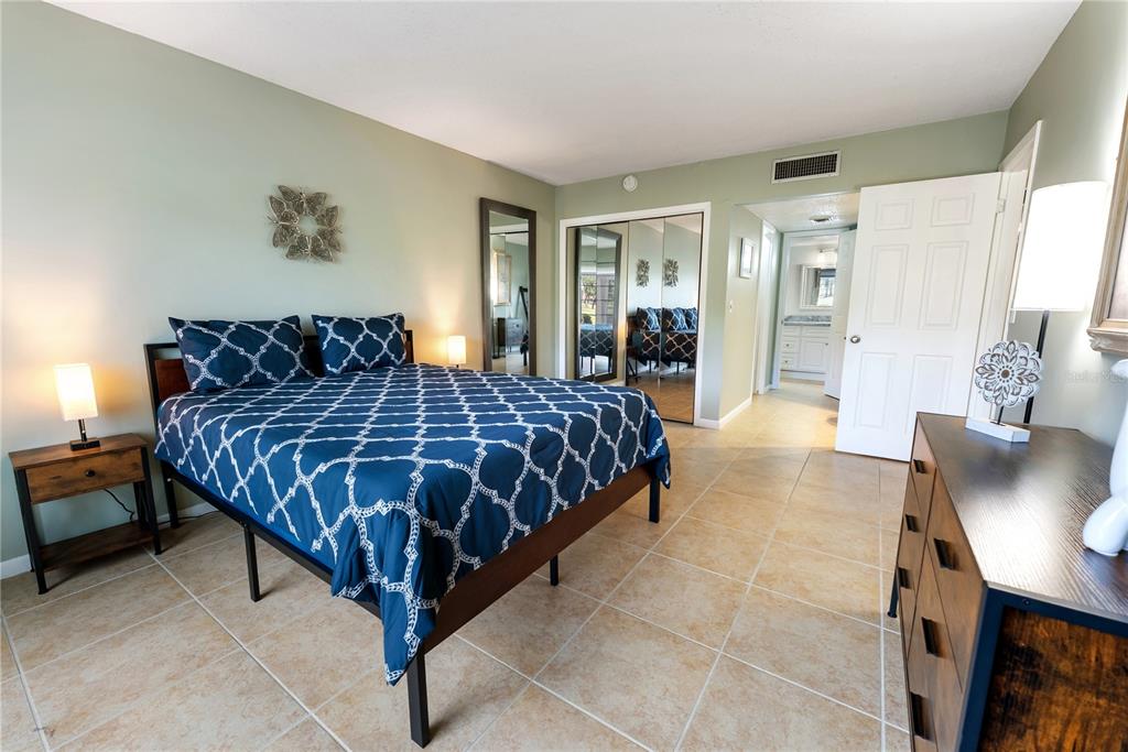 7351 West Country Club Drive North, Unit 103 Sarasota, FL 34243 - Photo 16 of 26 a bedroom with a large bed and a couch