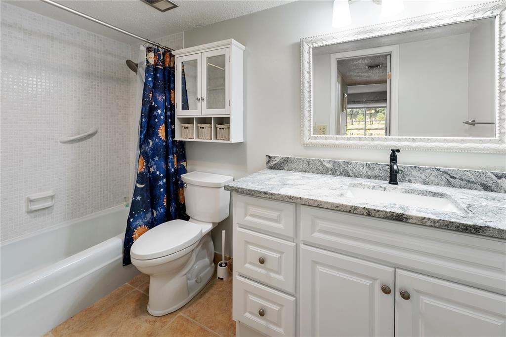 7351 West Country Club Drive North, Unit 103 Sarasota, FL 34243 - Photo 18 of 26 a bathroom with a granite countertop sink toilet and shower