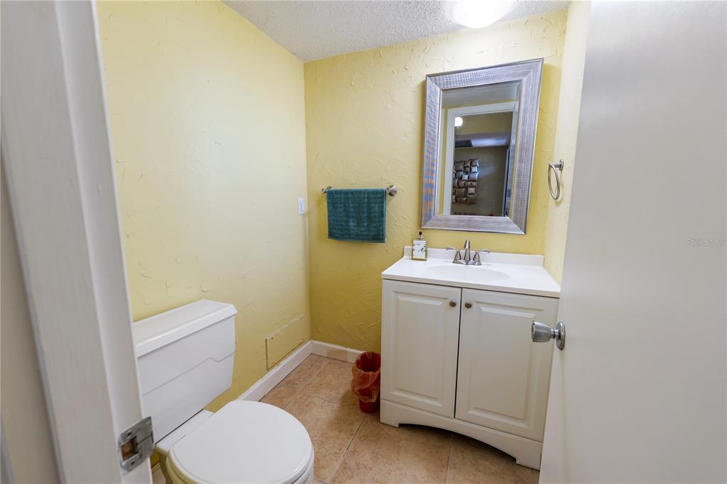 7351 West Country Club Drive North, Unit 103 Sarasota, FL 34243 - Photo 21 of 26 a bathroom with a sink a toilet and mirror