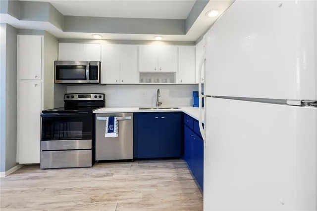 a kitchen with stainless steel appliances a refrigerator and a stove top oven