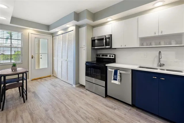 a kitchen with stainless steel appliances granite countertop a stove a sink and a refrigerator