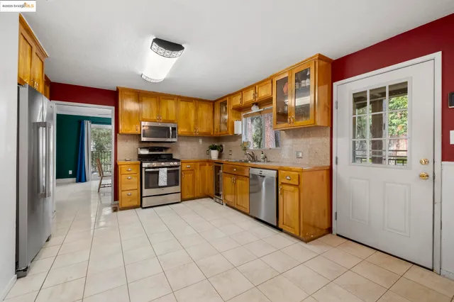 a kitchen with stainless steel appliances granite countertop a stove a sink and a refrigerator