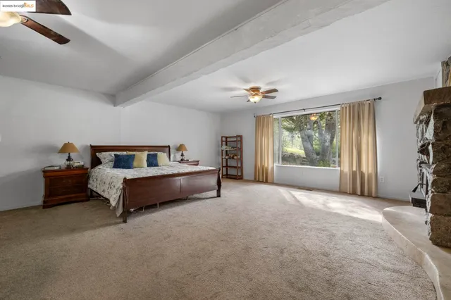 a spacious bedroom with a bed and a chandelier