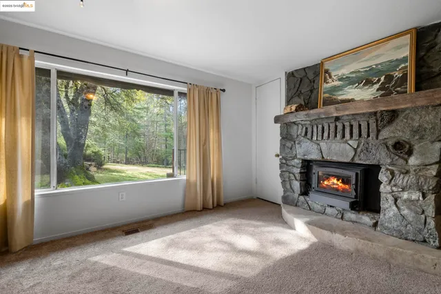 a view of an empty room with window and fire place