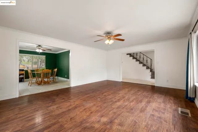 a view of an empty room with wooden floor and a glass door