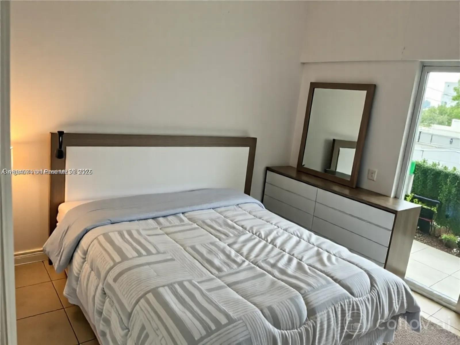 1020 Southwest 4th Street, Unit 103 Miami, FL 33130 - Photo 3 of 11 a bedroom with a bed and a mirror