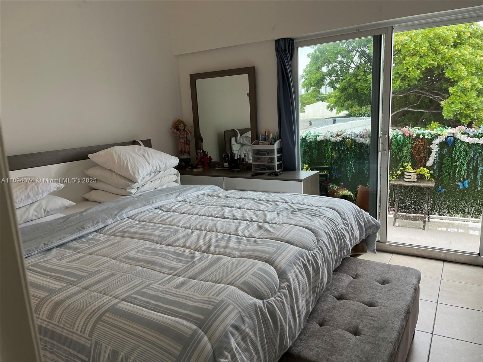 1020 Southwest 4th Street, Unit 103 Miami, FL 33130 - Photo 9 of 11 a bedroom with a large bed and a large window