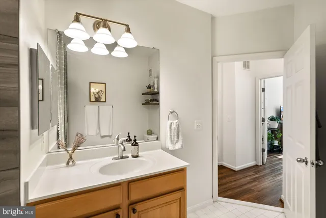 a kitchen with stainless steel appliances granite countertop a table chairs in it and wooden floors