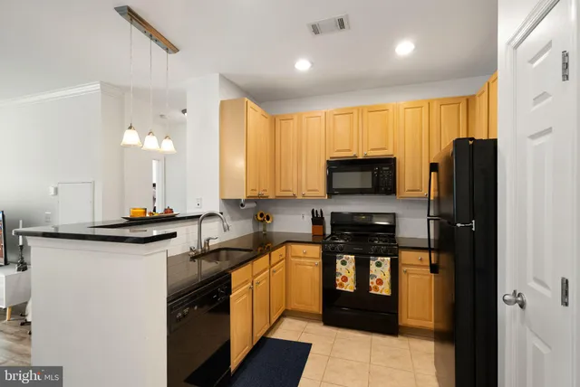 a kitchen with granite countertop a stove a sink and a microwave