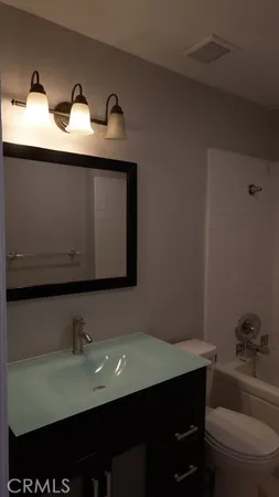 a bathroom with a sink a toilet and a mirror