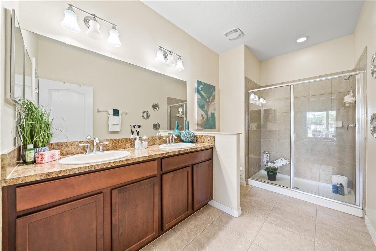 3795 Sansome Circle Melbourne, FL 32940 - Photo 15 of 76 a bathroom with a double vanity sink and mirror with shower