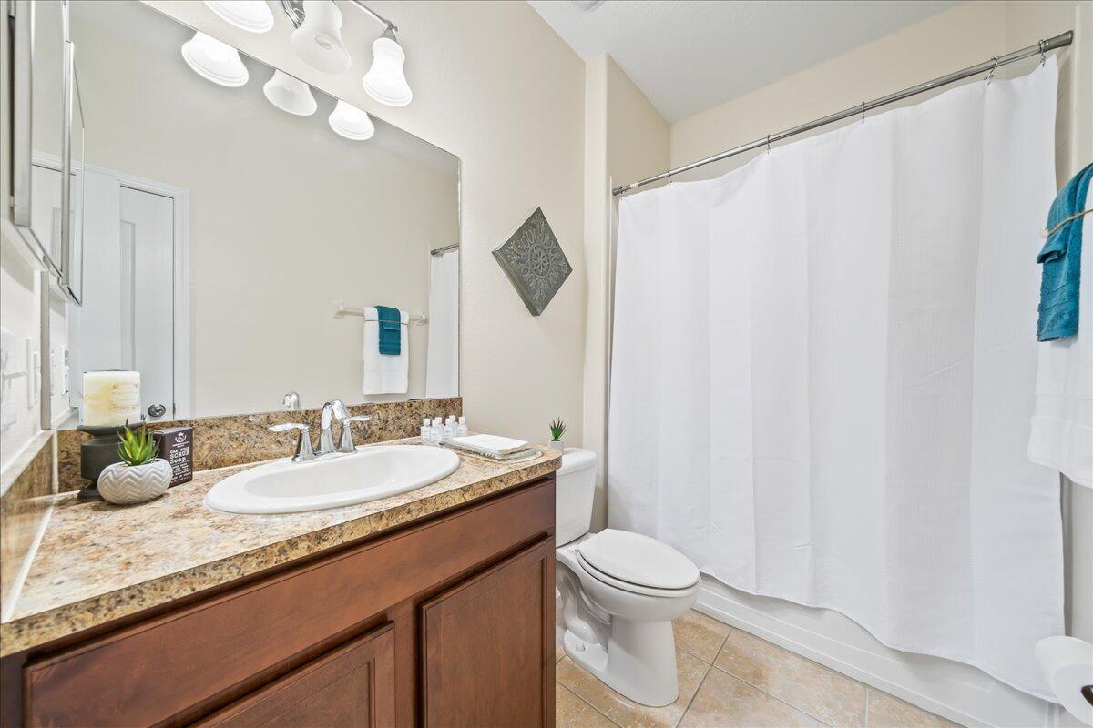 3795 Sansome Circle Melbourne, FL 32940 - Photo 20 of 76 a bathroom with a granite countertop sink a toilet and a mirror