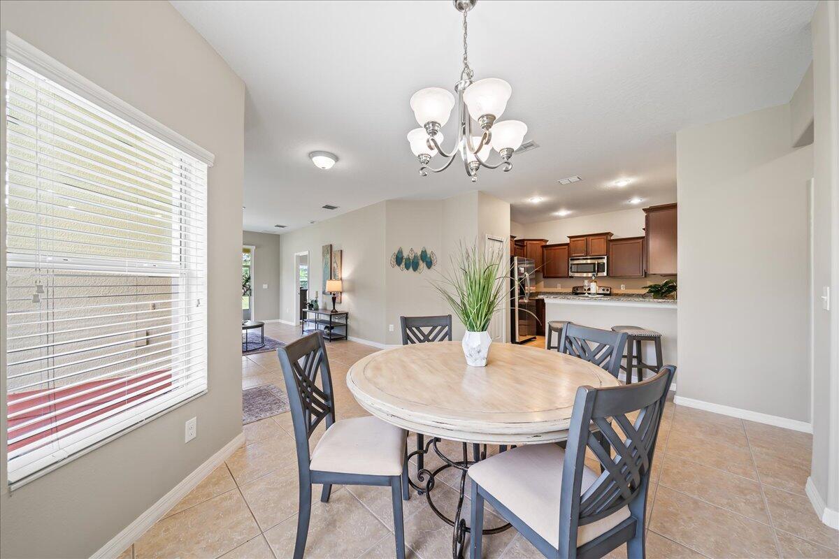 3795 Sansome Circle Melbourne, FL 32940 - Photo 8 of 76 a view of a dining room with furniture a chandelier and wooden floor